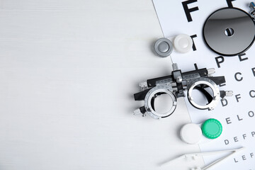 Different ophthalmologist tools on white wooden background, flat lay. Space for text