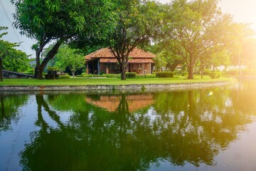 Beautiful view with little house in the green forest. Sunrise in the countryside with house reflection of river. 