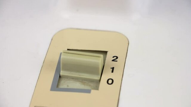 fingers flip toggle the old retro switch, select fan speed two, one, zero, close-up view, the ternary numeral system of calculations