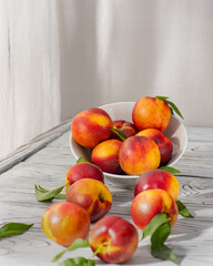 Ripe and tasty and juicy peaches lie on a plate on a wooden table. Large peaches on rustic wooden background, selective focus.