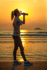 Woman drinking water on beach - 446639798