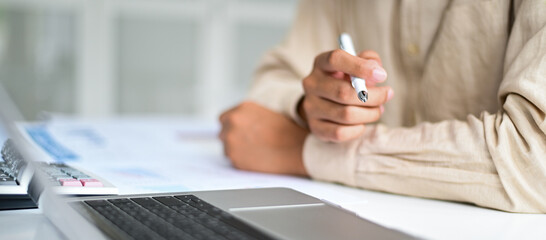 Fototapeta premium Cropped shot of Businessman holding pen in hand on desk,Business concepts.