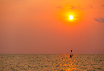 Surfer surfing alone in sea at sunset