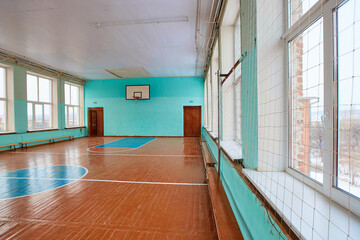 A school sports hall that has not been repaired for many years with an old wooden floor