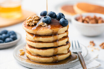 Syrup pouring over blueberry pancakes. Sweet breakfast food