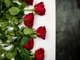 A bouquet of roses lie on a white and black wooden background. Flower rose. Postcard. Background and texture.