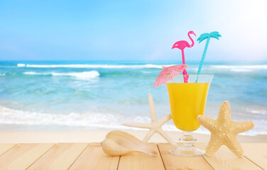 image of tropical and exotic fruit coctail over wooden table infront of sea landscape background