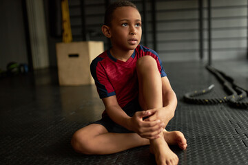 Naklejka premium Cute kid posing for sports school album, photoshot in gym, roll of honor. Latino american boy making progress in sport, future champion. Sport career, success, professional sportsman concept