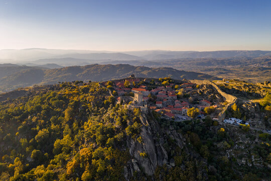 Drone aerial panorama of historic village of Sortelha with castle and with turbines on natural landscape, Centro, Portugal