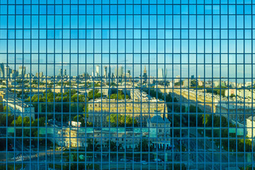 Aerial view of Warsaw city center reflecting in office building with green windows
