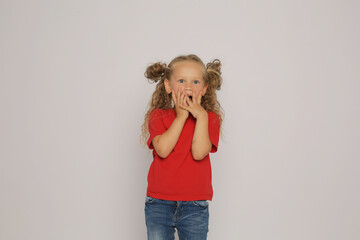 a beautiful blonde girl with ponytails in a red T-shirt shows various emotions sadness ,surprise, fear ,happiness