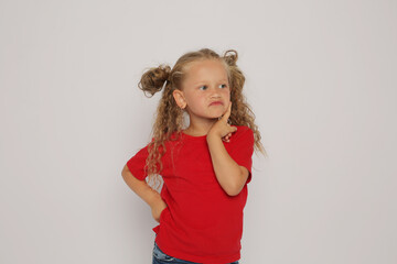 a beautiful blonde girl with ponytails in a red T-shirt shows various emotions sadness ,surprise, fear ,happiness