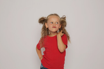 a beautiful blonde girl with ponytails in a red T-shirt shows various emotions sadness ,surprise, fear ,happiness