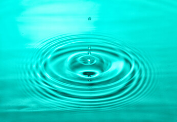 falling drops on the water surface, splash, ripples on the water, turquoise color