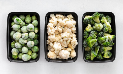Set of frozen cabbage. Brussels sprouts, cauliflower and broccoli in containers on a white...