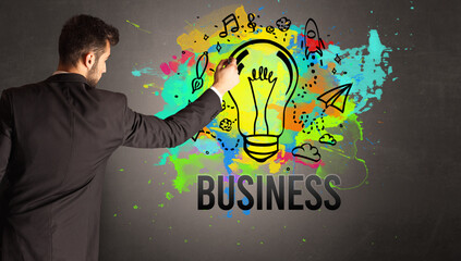 businessman drawing colorful light bulb