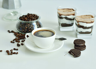 cup of black coffee and coffee beans, dessert in a glass. Cheesecake with chocolate and cottage cheese cream
