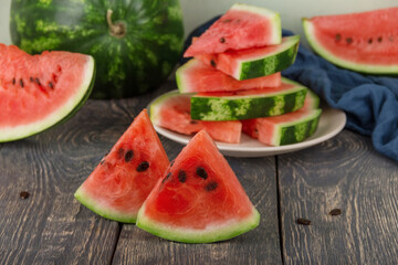 Sliced juicy tasty pieces of watermelon on dark boards