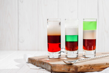 Three colorful cocktails shots on a white background. Strong alcoholic drinks and tequila. High quality photo