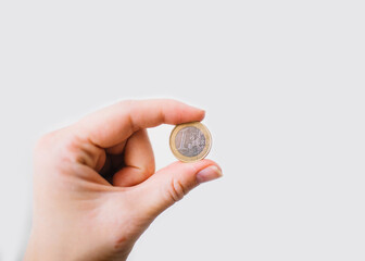 hand holding one euro coin on the white background