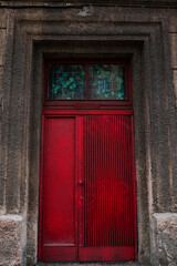 A red wooden door, entrance to the staircase