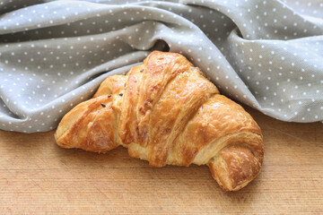 French croissant made of puff pastry on a wooden table.