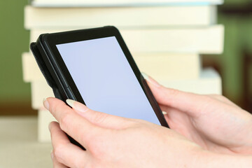 A woman is holding an e-book reader in her hands