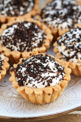 Tiny cupcakes with chocolate on the table.