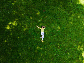 overhead view of woman laying down on green grass