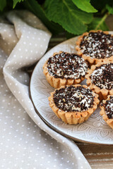 Tiny cupcakes with chocolate on the table.