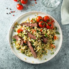 Couscous salad with grilled beef steak and herbs