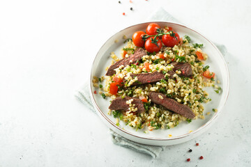 Couscous salad with grilled beef steak and herbs