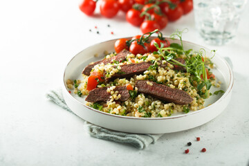 Couscous salad with grilled beef steak and herbs