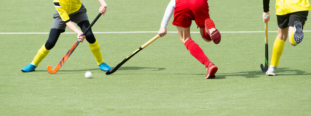 Three man battle for control of ball during field hockey game. Horizontal sport poster, greeting cards, headers, website