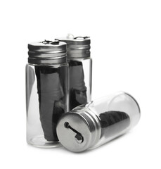 Rolls of natural organic dental floss in jars on white background