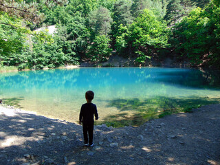 a boy is looking at Blue Lake in Baia Sprie, Maramures