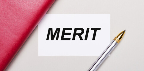 On a light gray background, there is a golden pen, a burgundy notebook and a white blank card with a place to insert text. Business concept. Template