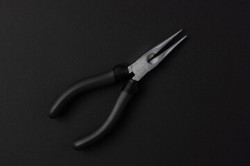 Isolated metal pliers with plastic black handles