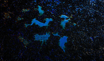 Oil stain on Asphalt road after rain, color Gasoline fuel spots on Asphalt Road