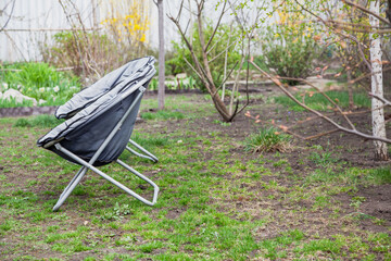 Two portable chairs stand in yard on grass