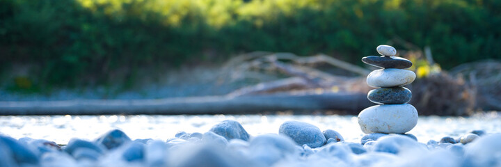 stones stacked on the river bank. Concept: nature, mental balance, meditation, relax, pace, zen. banner