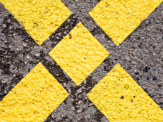 Yellow cross on an asphalt road