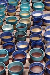High angle view of a display of colorful handmade ceramic flowerpots