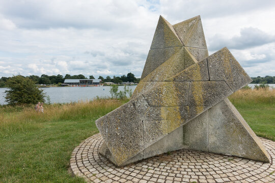 Ferry Meadows-Peterborough-UK-July 17,2021 -A sculpture by John Maine called Pyramid with lake and recreation centre behind