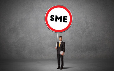 Fototapeta premium Young business person holdig traffic sign