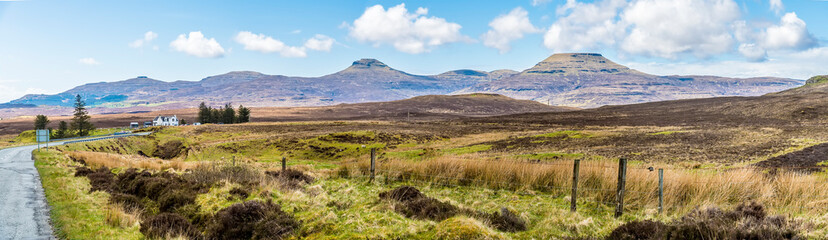 A panorama view across the heathland on the island of Skye towards the flat topped mountains of MacCeods tables, Scotland on a summers day