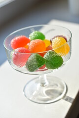 Marmalade in sugar in a glass vase on a white background