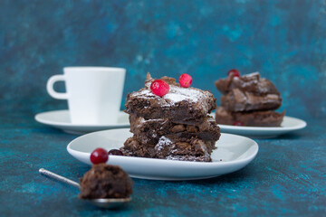 Pieces of sweet chocolate brownie cake on a white plate. Delicious not healthy food, dessert