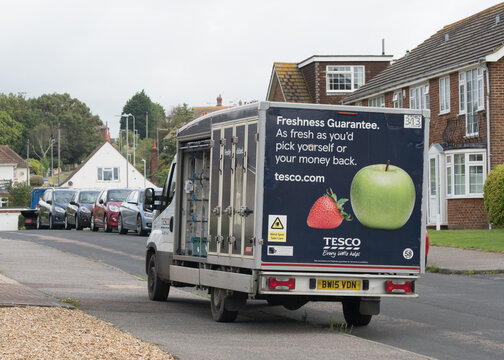 A Tesco delivery van parked on a pavement curb side in a residential area.Online home shopping