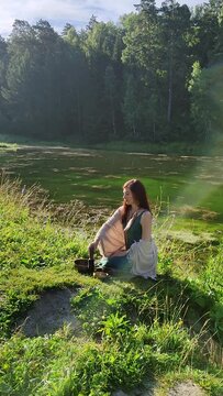 a yogi woman in nature holds a singing massage cup on which the mantra "om mani padme hum" is written 